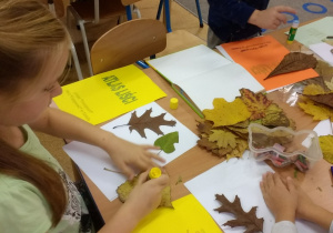 Przedszkolaki naklejaja liście